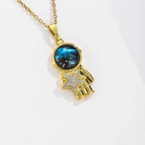 Detailed macro view of a gold astronaut pendant featuring a blue starry sphere and cz star