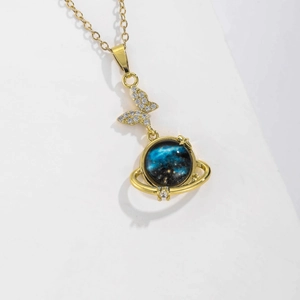 Detail of starry planet pendant with crystal butterfly on gold chain necklace