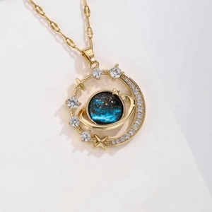 Detailed close-up of a blue planet pendant with golden star and sparkling crystals