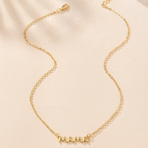 Close-up of golden MAMA pendant with polished finish and delicate lobster clasp chain