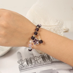 Elegant purple crystal star and flower charm beaded bracelet for women on a wrist