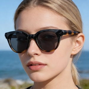 Gros plan de lunettes de soleil œil-de-chat avec monture noire facettée et branches écaillées