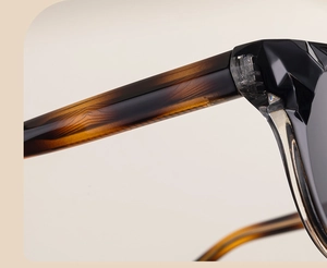 Détail de lunettes de soleil œil de chat avec monture géométrique noire et branches ambre