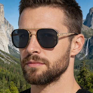 Close-up of square double-bridge sunglasses with gold metal carved temples on model