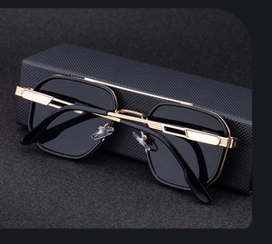Detail of square sunglasses with gold accents on textured black case with felt background