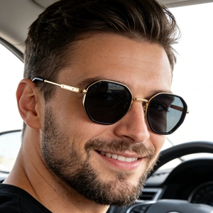 Retro hexagonal driving sunglasses with black frames and gold metal temples on male model