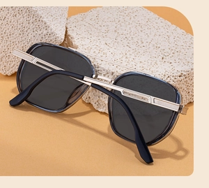 Close-up of square sunglasses with textured silver metal temples on white stones
