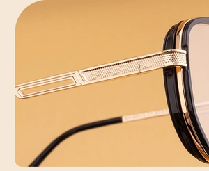 Detailed macro view of the gold metal hinge and textured pattern on square sunglasses