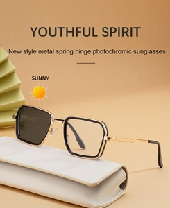 Detail of square photochromic sunglasses featuring gold-toned metal spring hinge temples