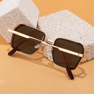 Detail of square photochromic sunglasses with gold metal temples and textured engraving