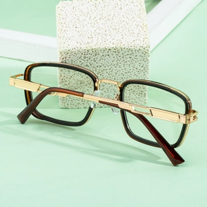 Detail of square tortoiseshell glasses frame with golden metal and geometric temple accents