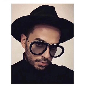 Detailed close-up of oversized black sunglasses featuring sparkling rhinestone embellishments