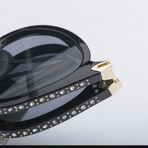 Detail of folding sunglasses with golden H hinge and sparkling rhinestone temple decor