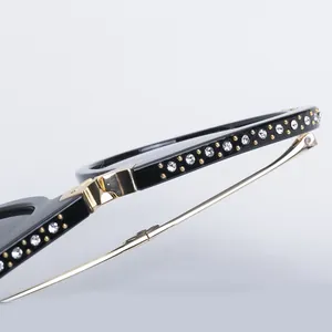 Macro detail of black frame with double-row rhinestone inlay and gold metal temples