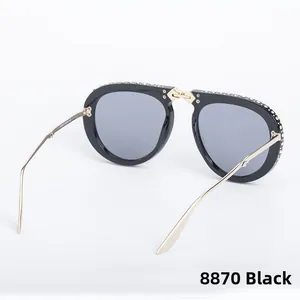Detailed macro view of black pilot sunglasses with crystal encrusted frames and gold arms