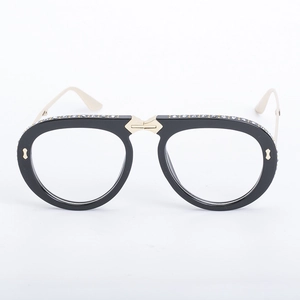 Detail of oversized black frame glasses with sparkling rhinestones and gold metal accents