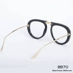 Detail of folding sunglasses with rhinestone inlay on black frame and gold metal temples