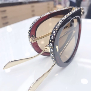 Detail of fashion round oversized sunglasses with rhinestone-encrusted frames and gold metal temples