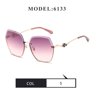 Detail of pink gradient rimless lens with gold metal temple and black rose floral motif