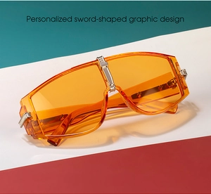 Detail of orange oversized sunglasses with unique sword-shaped metal temple decoration
