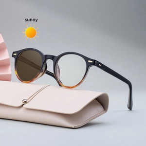 Women's photochromic round sunglasses with amber accents and beige leather case