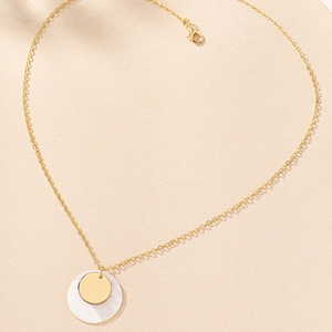 Close-up of golden chain necklace with layered shell and polished disc pendants