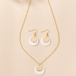 Detailed view of elegant gold-toned shell pendant necklace and matching drop earrings