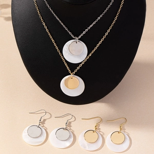 Elegant gold and silver jewelry set with minimalist shell disc necklaces and earrings