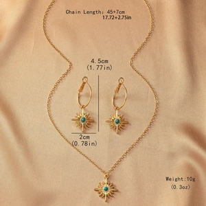 Parure bijoux étoile dorée avec pierre turquoise sur satin couleur champagne