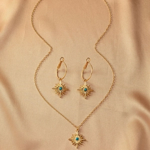 Détails d'une parure vintage dorée avec perles turquoises sur un fond en soie élégant