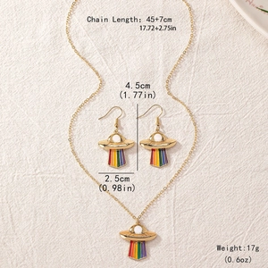Colorful rainbow UFO jewelry set with gold necklace and earrings on textured fabric