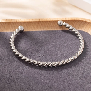 Bracelet jonc torsadé argenté minimaliste avec embouts boules sur plateau bois