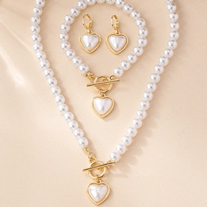Détails de l'élégant ensemble de bijoux en perles avec cœurs et fermoirs à bascule dorés