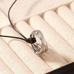 Macro view of triple interlocking rings necklace pendant with a polished silver finish
