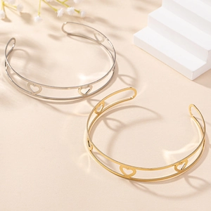 Détail du motif cœur évidé sur des colliers ras du cou minimalistes or et argent