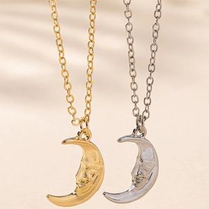 Detail of elegant gold and silver crescent moon face pendants on fine link chains