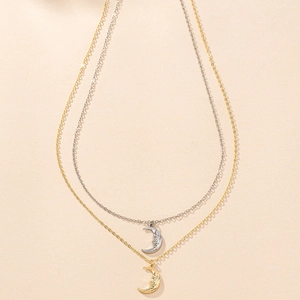 Elegant double-layered necklace featuring gold and silver crescent moon face pendants