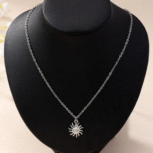 Elegant silver sun face pendant necklace displayed on a black neck mannequin