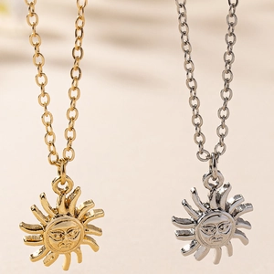 Detailed view of sun face necklaces in gold and silver with embossed metallic rays