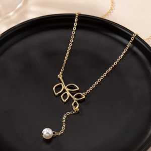 Elegant gold necklace with hollow leaf pendant and white pearl on a black display base