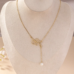 Elegant gold-tone necklace featuring a hollow leaf pendant with a white pearl drop detail