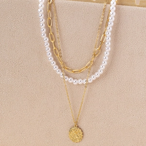 Collier doré à trois rangs avec perles et pendentif médaillon sur présentoir bijoux