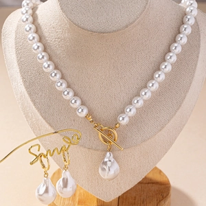 Elegant baroque pearl necklace and earrings set with gold OT clasp on display stand
