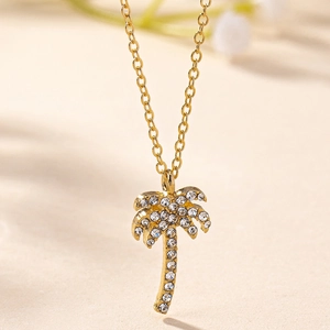 Macro detail of gold coconut tree pendant with sparkling diamonds and delicate chain
