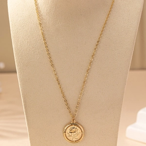 Elegant gold-plated coin necklace with hollow rose flower pendant on a jewelry bust