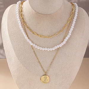 Three-layer layered necklace featuring paperclip chain, pearls, and coin pendant