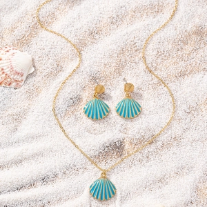 Detailed view of sky blue shell jewelry set on white beach sand for summer vacation