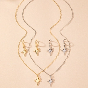 Detailed close-up of gold and silver four-pointed star pendant necklace and earring set
