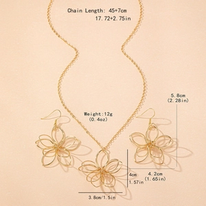 Parure bijoux fleurs dorées évidées avec collier et boucles d'oreilles sur fond rose