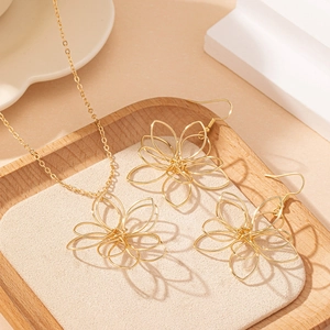 Parure de bijoux dorés avec collier et boucles d'oreilles au motif floral ajouré chic